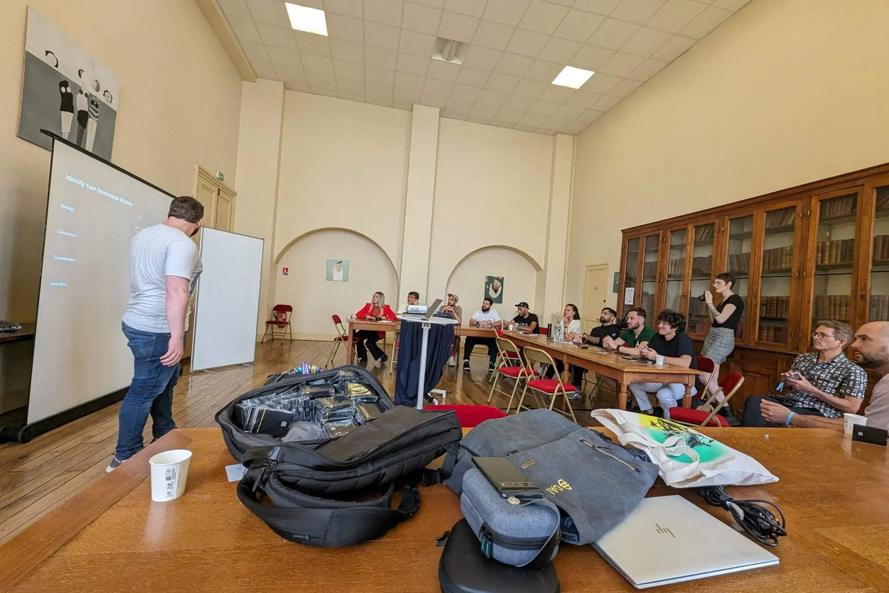 The workshop room at the Sorbonne: a slide shows the four suits, and a bag full of decks sits on the front table.