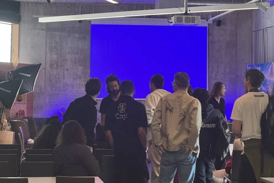 People talk in groups in the Zuitzerland workshop room after a session.